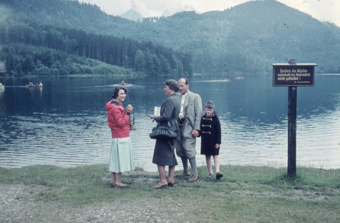 A dusty holiday slide of a family beside an Alpine lake